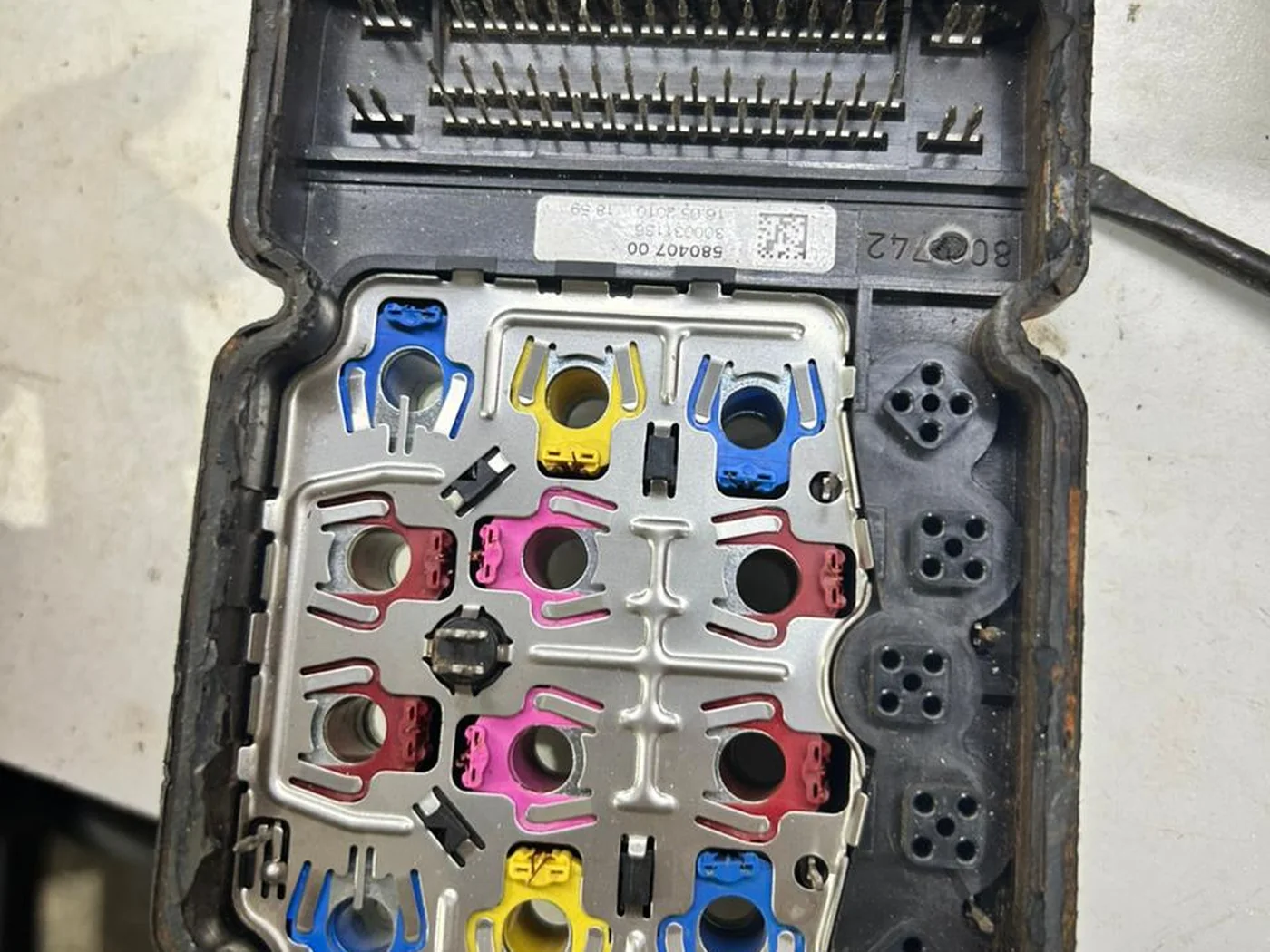 Módulo ABS aberto mostrando o bloco hidráulico com as bobinas das válvulas e o conector de vias do chicote